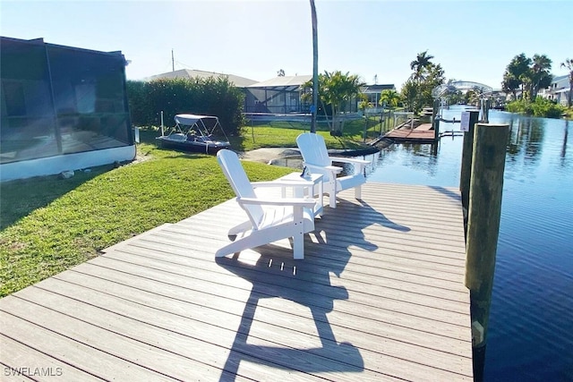 dock area with a yard and a water view