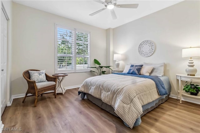 bedroom with baseboards, wood finished floors, a closet, and a ceiling fan