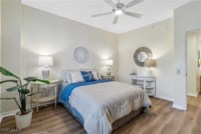 bedroom with wood finished floors, baseboards, and a ceiling fan