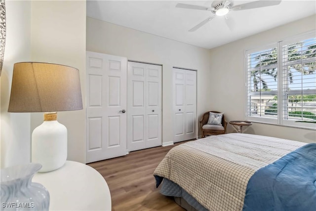 bedroom with multiple closets, wood finished floors, and ceiling fan