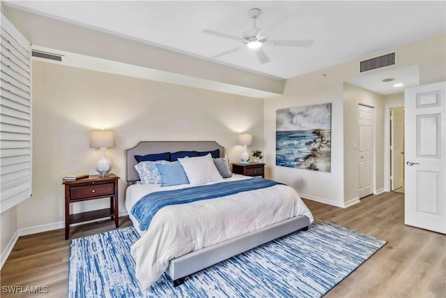 bedroom featuring wood finished floors, baseboards, and a ceiling fan