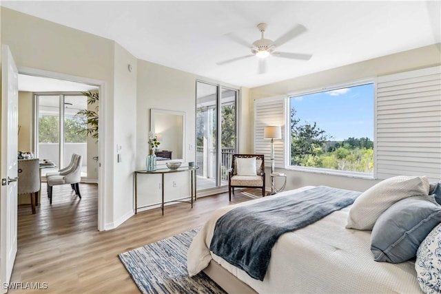 bedroom featuring multiple windows, light wood-type flooring, access to outside, and baseboards