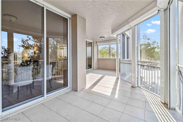 unfurnished sunroom with tile patterned floors and a textured ceiling