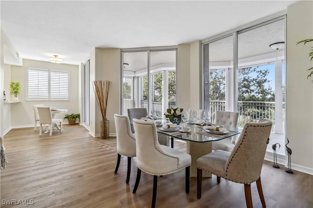 dining space featuring plenty of natural light, wood finished floors, and baseboards