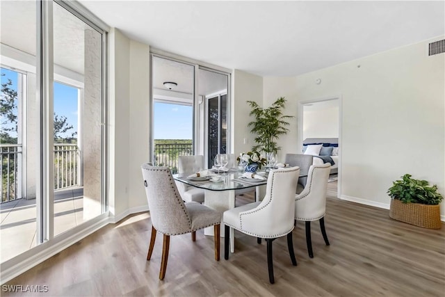dining area with healthy amount of natural light, wood finished floors, and baseboards