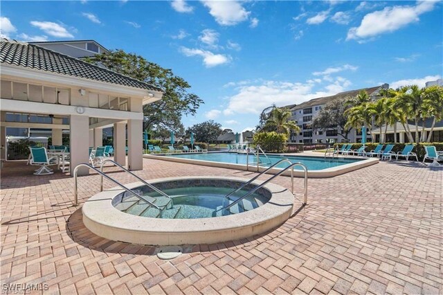 community pool featuring a hot tub and a patio