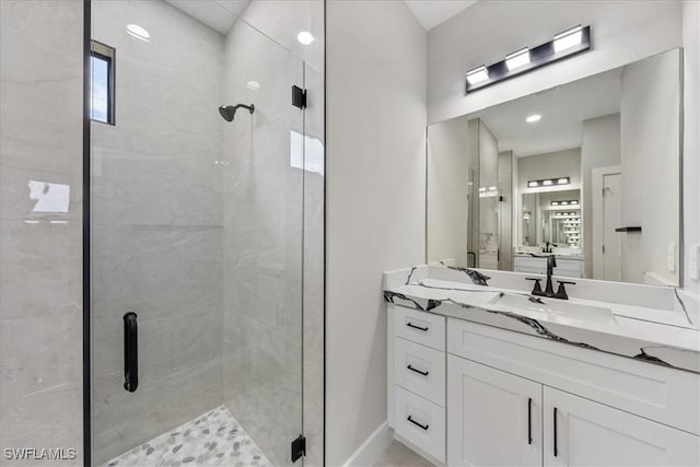 full bath featuring baseboards, a stall shower, and vanity