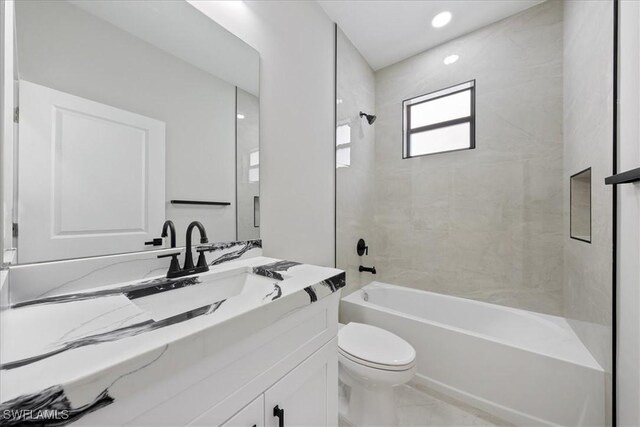 bathroom with bathing tub / shower combination, vanity, and toilet