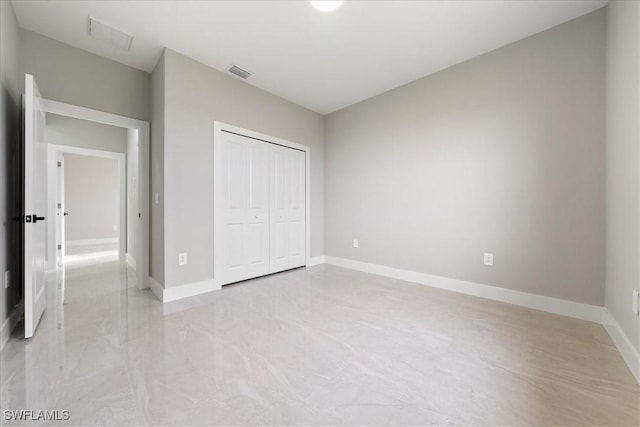 unfurnished bedroom featuring baseboards, visible vents, and a closet
