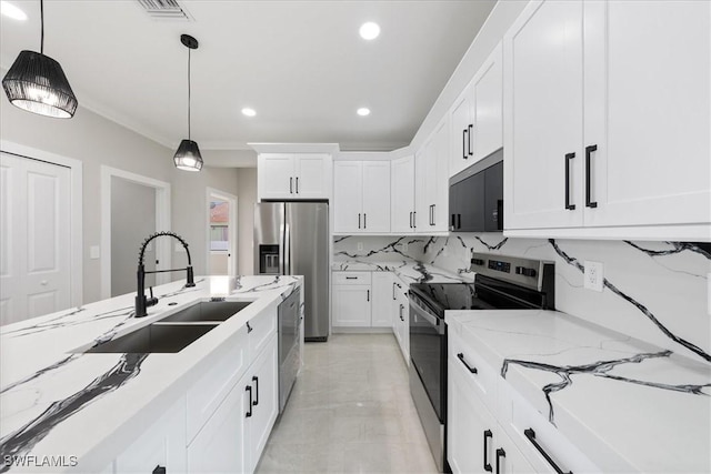 kitchen featuring a sink, stainless steel appliances, tasteful backsplash, and white cabinets