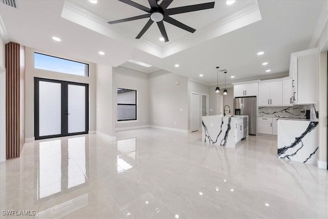 unfurnished living room featuring crown molding and a raised ceiling