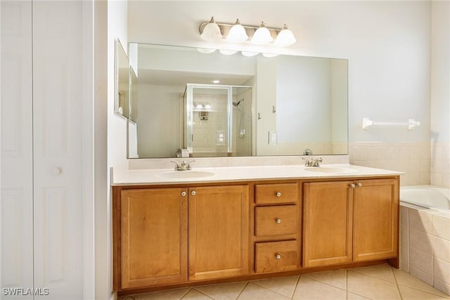bathroom with a stall shower, tile patterned flooring, double vanity, and a relaxing tiled tub