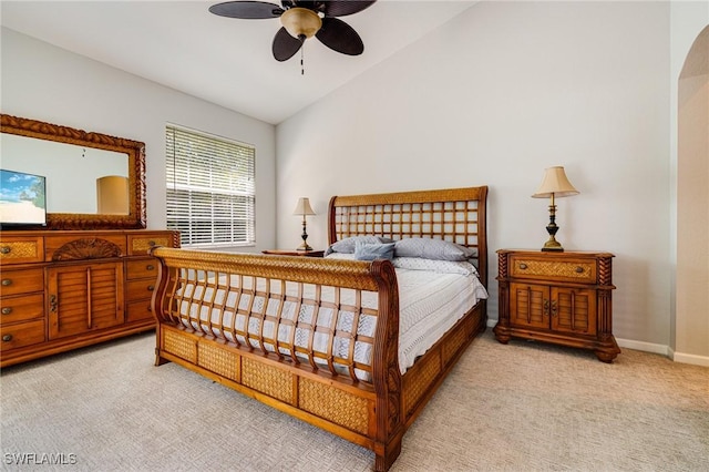bedroom featuring vaulted ceiling, light carpet, a ceiling fan, and baseboards