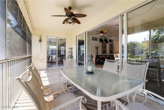 sunroom with ceiling fan and outdoor dining space