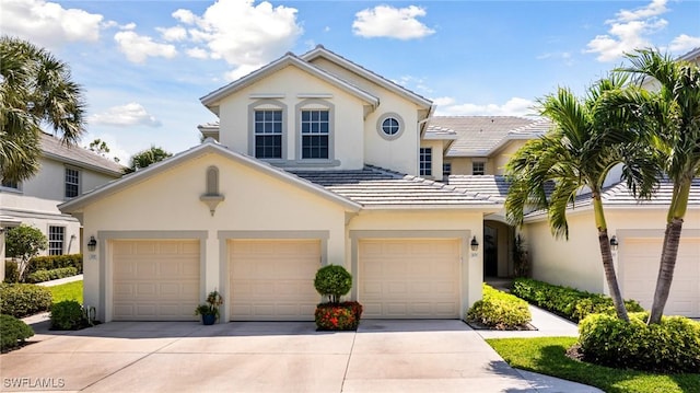 view of front of home with driveway, stucco siding, a garage, and a tiled roof
