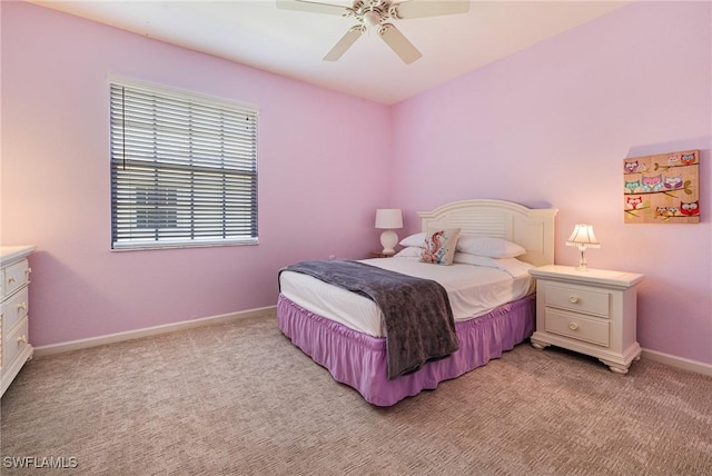 bedroom featuring light colored carpet, baseboards, and a ceiling fan