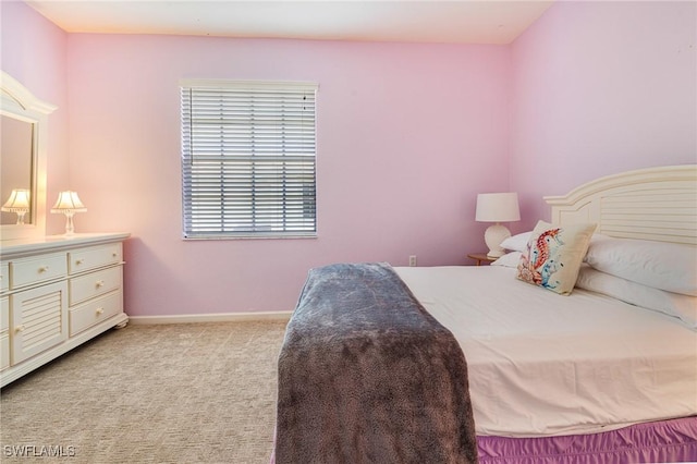 bedroom with light carpet and baseboards