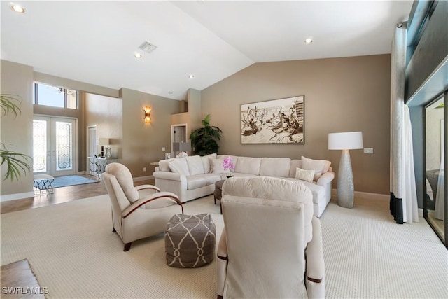 living room with baseboards, visible vents, high vaulted ceiling, and french doors