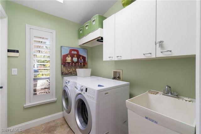 washroom with independent washer and dryer, a sink, cabinet space, and baseboards