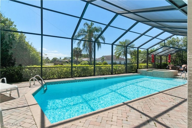 view of pool with a pool with connected hot tub, glass enclosure, and a patio area