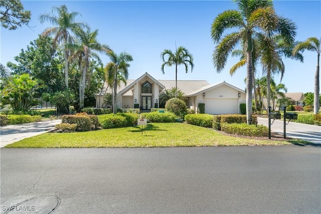 view of front facade with a garage, concrete driveway, and a front yard