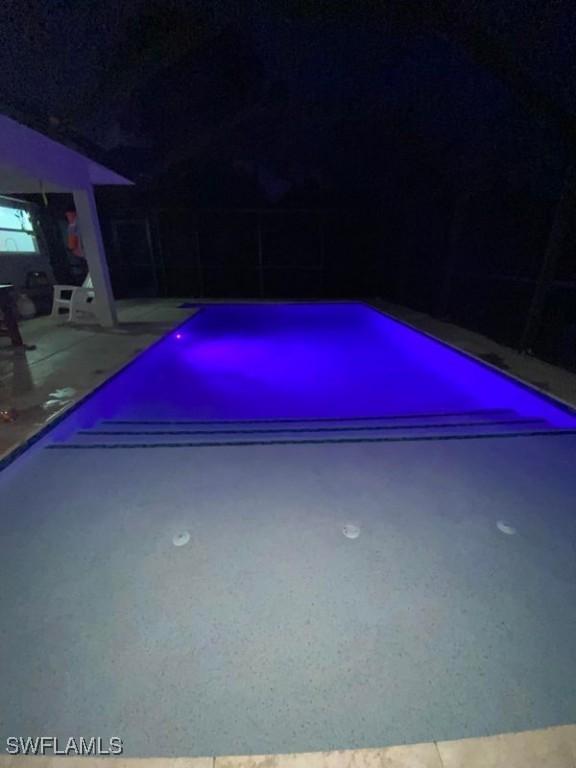 4015 1st St SW, Lehigh Acres, FL 33976 - pool at night with an outdoor pool and a patio