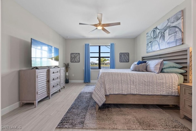 bedroom featuring a ceiling fan, baseboards, and wood tiled floor