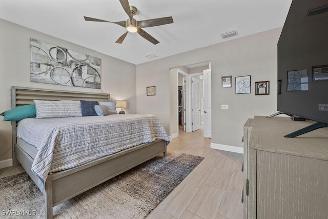 bedroom featuring light wood-type flooring, visible vents, baseboards, and ceiling fan