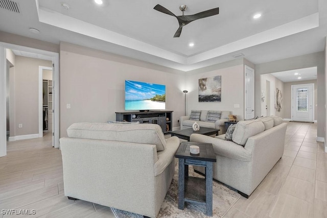 living area with visible vents, a ceiling fan, recessed lighting, baseboards, and a raised ceiling
