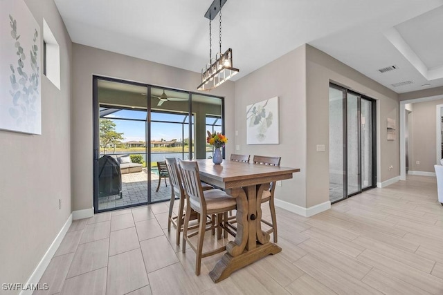 dining space featuring visible vents, wood finish floors, a ceiling fan, and baseboards