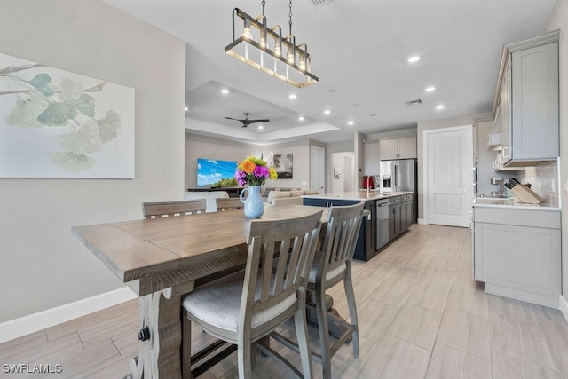 dining room with a ceiling fan, baseboards, visible vents, a tray ceiling, and recessed lighting