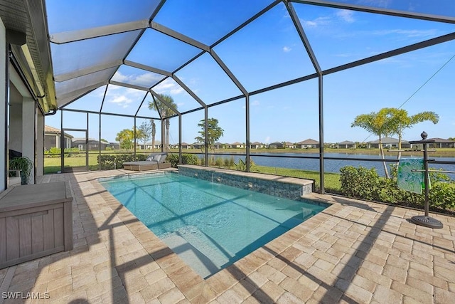 pool with glass enclosure, a water view, and a patio area