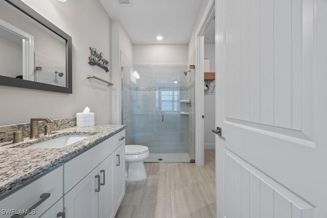 full bath featuring visible vents, a shower stall, vanity, and toilet