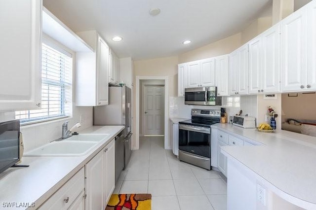7520 Firenze Ln, Naples, FL 34114 - kitchen with light countertops, white cabinets, appliances with stainless steel finishes, and a sink