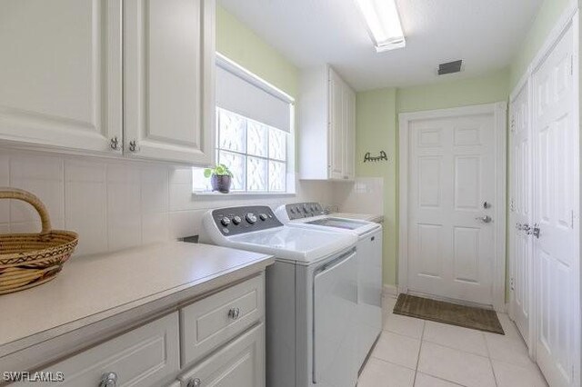 7520 Firenze Ln, Naples, FL 34114 - clothes washing area featuring visible vents, light tile patterned floors, cabinet space, and independent washer and dryer