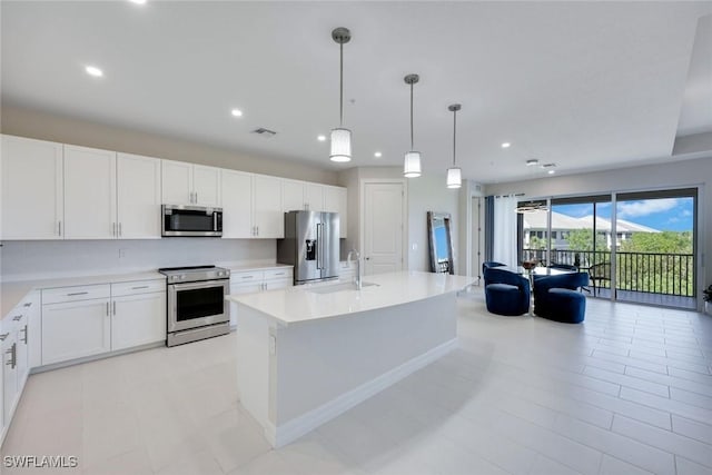 kitchen featuring visible vents, a sink, open floor plan, appliances with stainless steel finishes, and light countertops
