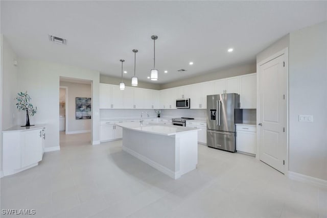 kitchen featuring visible vents, light countertops, white cabinets, stainless steel appliances, and a kitchen island with sink