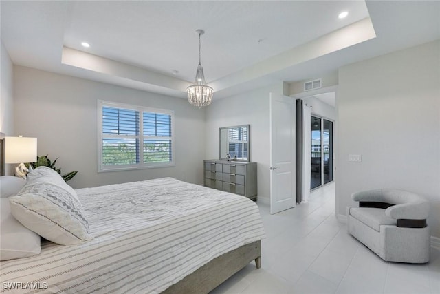 bedroom with visible vents, an inviting chandelier, and a tray ceiling