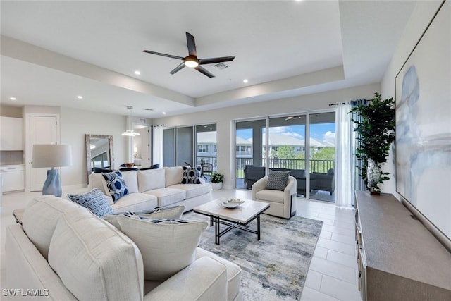 living room featuring visible vents, a ceiling fan, a tray ceiling, recessed lighting, and light tile patterned flooring