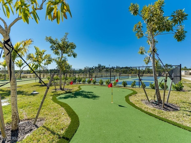 surrounding community featuring a tennis court and fence