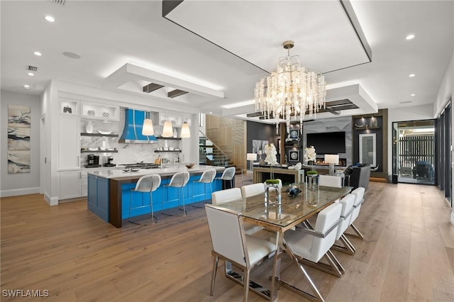 dining area with stairs, a notable chandelier, light wood-type flooring, visible vents, and recessed lighting