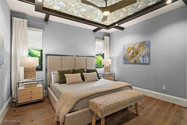 bedroom featuring hardwood / wood-style floors, baseboards, and multiple windows