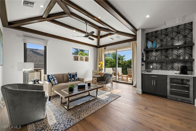 living area with wet bar, wine cooler, ceiling fan, visible vents, and wood finished floors