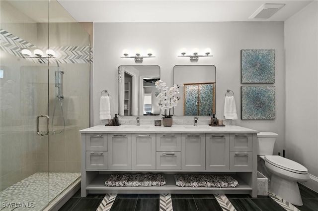 full bathroom featuring a stall shower, toilet, a sink, visible vents, and double vanity
