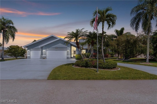 view of front facade with a front yard, concrete driveway, and an attached garage