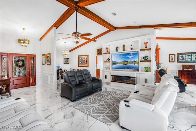 living area with marble finish floor, vaulted ceiling with beams, a wainscoted wall, and ceiling fan with notable chandelier