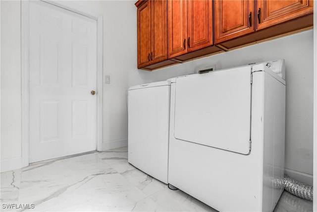 laundry room featuring marble finish floor, washer / clothes dryer, cabinet space, and baseboards