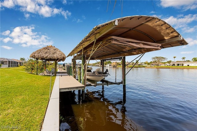 view of dock featuring a water view, boat lift, and a yard