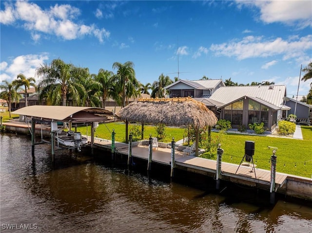 dock area with boat lift, a water view, glass enclosure, and a lawn