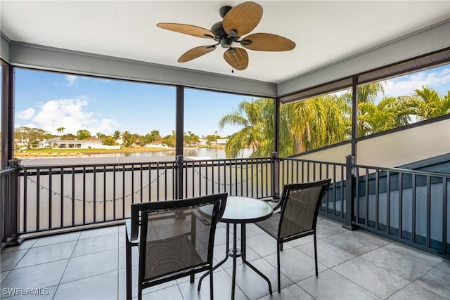 sunroom featuring a wealth of natural light, a water view, and ceiling fan